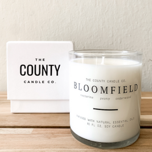 Bloomfield hand-poured nectarine, peony, and cedar wood premium soy candle in a clear glass jar made by The County Candle Co.  Hand-poured and made from 100% premium soy wax, cotton wicks, and phthalate-free fragrances infused with essential oils, we pride ourselves on creating luxurious candles using time-honored technique and eco-conscious materials. Made in Prince Edward County, Ontario, Canada. 