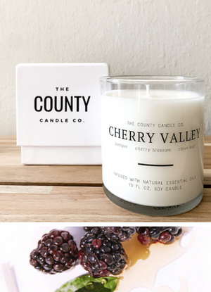 Open image in slideshow, Cherry Valley hand-poured juniper, cherry blossom, and clove leaf premium soy candle in a clear glass jar made by The County Candle Co.  Hand-poured and made from 100% premium soy wax, cotton wicks, and phthalate-free fragrances infused with essential oils, we pride ourselves on creating luxurious candles using time-honored technique and eco-conscious materials. Made in Prince Edward County, Ontario, Canada. 
