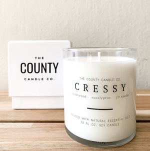 Cressy hand-poured cedar wood, eucalyptus, and fir needle premium soy candle in a clear glass jar made by The County Candle Co.  Hand-poured and made from 100% premium soy wax, cotton wicks, and phthalate-free fragrances infused with essential oils, we pride ourselves on creating luxurious candles using time-honored technique and eco-conscious materials. Made in Prince Edward County, Ontario, Canada. 