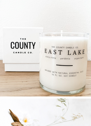 Open image in slideshow, East Lake hand-poured ylang ylang, gardenia, and argan bark premium soy candle in a clear glass jar made by The County Candle Co.  Hand-poured and made from 100% premium soy wax, cotton wicks, and phthalate-free fragrances infused with essential oils, we pride ourselves on creating luxurious candles using time-honored technique and eco-conscious materials. Made in Prince Edward County, Ontario, Canada. 
