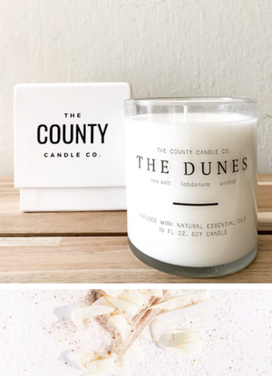 Open image in slideshow, The Dunes hand-poured sea salt, labdanum, and orchid premium soy candle in a clear glass jar made by The County Candle Co.  Hand-poured and made from 100% premium soy wax, cotton wicks, and phthalate-free fragrances infused with essential oils, we pride ourselves on creating luxurious candles using time-honored technique and eco-conscious materials. Made in Prince Edward County, Ontario, Canada. 
